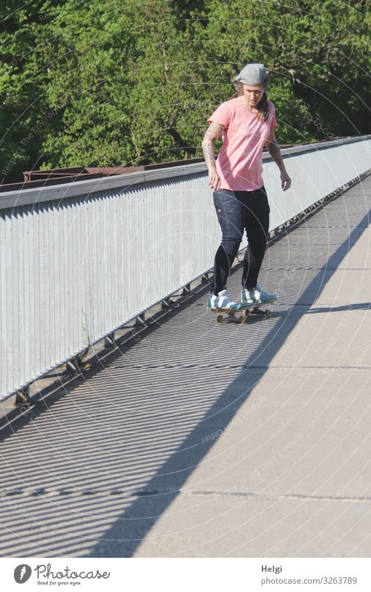 sporty lady rides her scateboard onto a bridge, the railing throws shadows Sports Fitness Sports Training Skateboard Human being Feminine Woman Adults 1