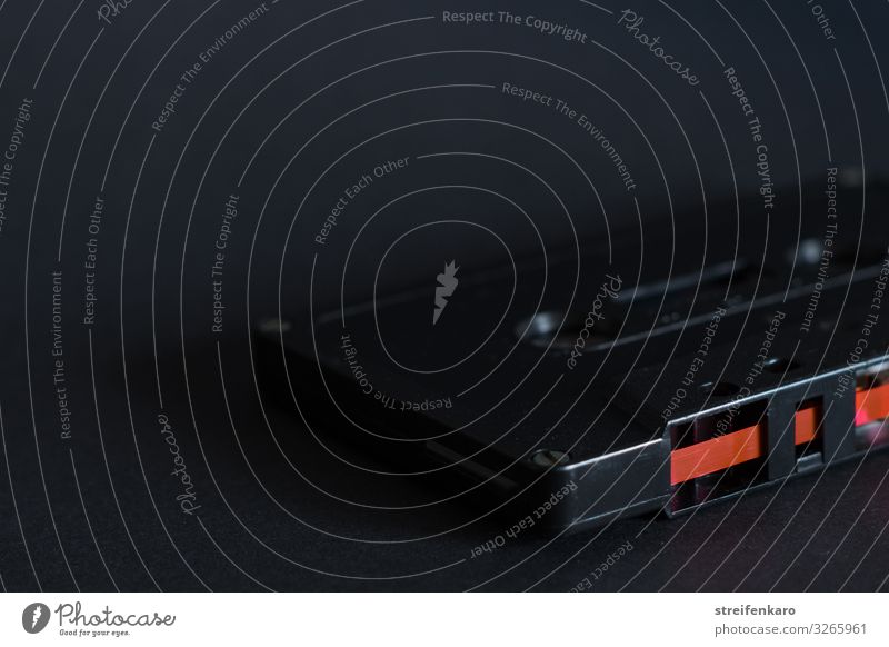 Old black music cassette on black background, with red magnetic tape Music Dance Listen to music Tape cassette Audio tape Media Dark Retro Red Black Advancement