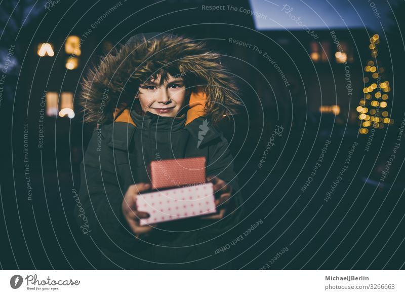 Boy with gifts in winter jacket Winter Christmas & Advent Child Human being Masculine Boy (child) 1 3 - 8 years Infancy Joy Gift Cold Jacket Street Blur Light