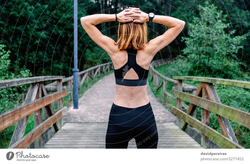 Unrecognizable sportswoman doing stretching arms outdoors Lifestyle Wellness Sports Human being Woman Adults Arm Nature Park Fitness Athletic Thin Backwards Top