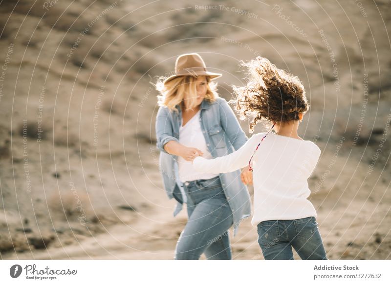 Mother dancing with girl on nature mother spin parent fun dance vacation daughter happy smile sand desert walk cheerful lifestyle modern child bonding love