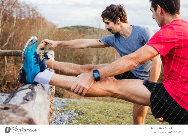 Sportsmen stretching after running in mountains sportsmen breath runner rest sportive relax break nature active jogger training together hill country green male