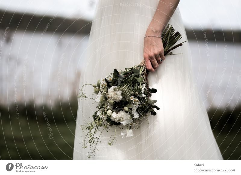 Bride holds white bridal bouquet at the lake Wedding dress moody Dress Meadow blurred Flower Woman Beautiful White Motion blur Romance youthful florist Nature