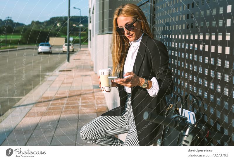 Businesswoman using mobile and drinking coffee with her scooter Lifestyle Style Beautiful Leisure and hobbies PDA Human being Woman Adults Street Fashion