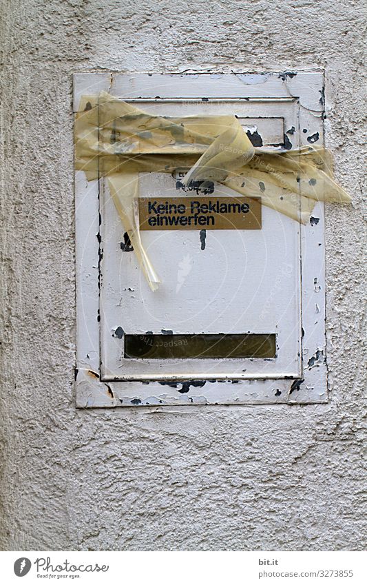 Writing on sign: Do not insert advertising, hangs on old, broken, white mailbox made of tin, on the wall of the house. The box is glued with parcel tape, tape, masking tape, closed as an indication of prohibition, tenant moving, vacancy.