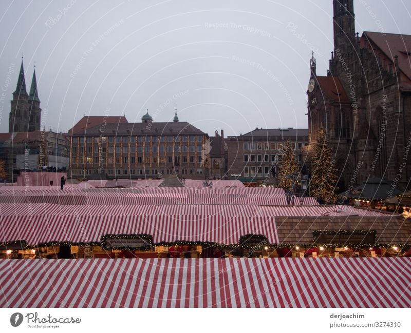 The Christmas market in Nuremberg is roofed. . The stalls are covered with red. White awnings roofed. In the background you can see half-timbered houses. Joy