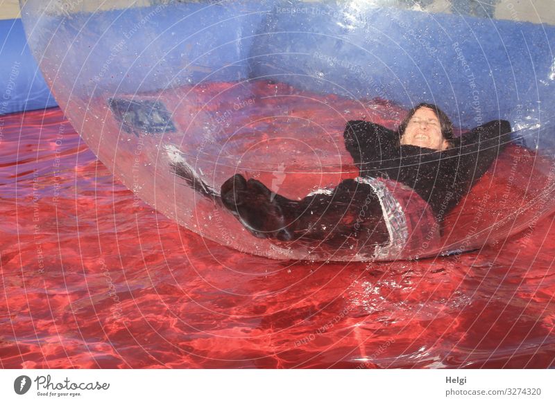 Woman lying relaxed in a big plastic ball in a water basin Human being Feminine Adults 1 45 - 60 years bubble Plastic Water Sphere Lie Swimming & Bathing