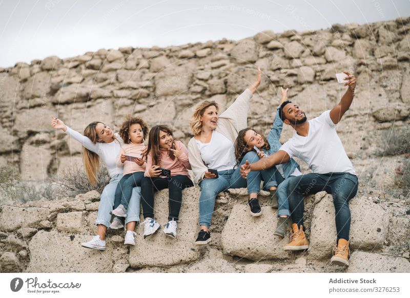 Big multiethnic family travelling together on nature selfie smile happy stone wall beige sight adventure vacation weekend children diverse black