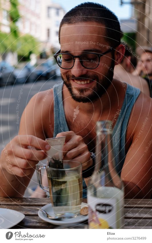 A man who sits outside in a café in the summer and drinks a tea and smiles Human being Masculine Young man Youth (Young adults) Man Adults Smiling Tea