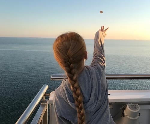 Make a wish. Far-off places Girl Hair and hairstyles Back 1 Human being 8 - 13 years Child Infancy Water Cloudless sky Horizon Sunrise Sunset Summer Ocean