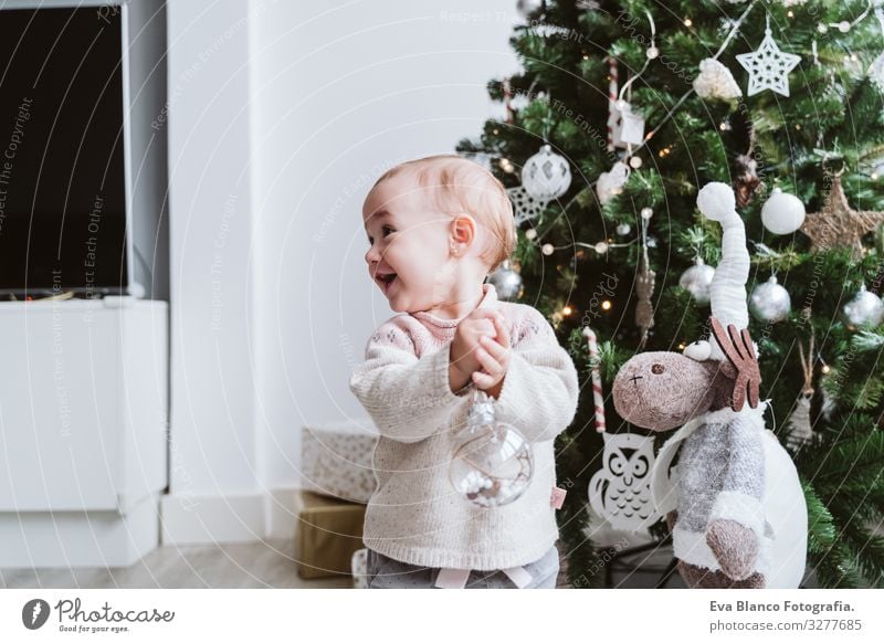 happy baby girl decorating the Christmas tree Happy Cute Baby Girl one year Christmas & Advent Tree Joy Family & Relations Love Decoration Infancy motherhood