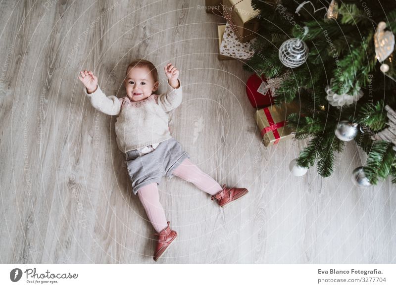 cute baby girl lying on the floor by the Christmas tree Lie (Untruth) Joy Happy Cute Baby Girl one year decorating Christmas & Advent Tree Family & Relations