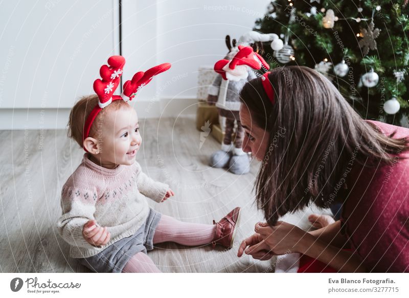 mother and cute baby girl playing at home with reindeer diadem. Christmas concept Playing Santa Claus Mother motherhood Happy Cute Baby Girl one year