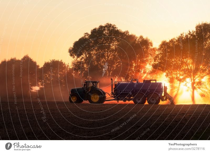 Tractor fertilizing agricultural field at sunset. Agriculture Work and employment Profession Nature Landscape Earth Orange Germany Action agriculture cultivate