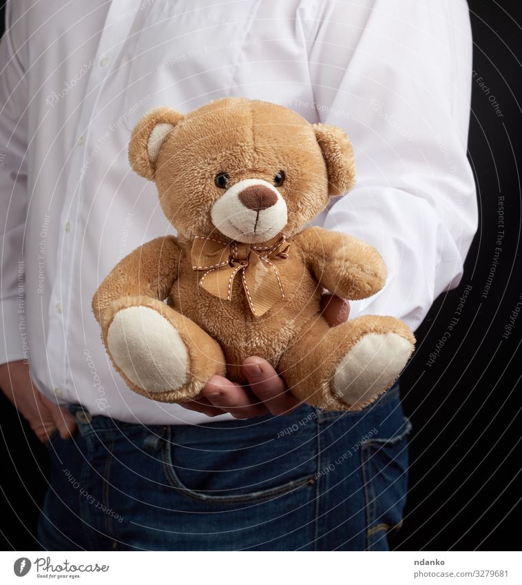 man in a white shirt holds a brown teddy bear Feasts & Celebrations Wedding Birthday Human being Man Adults Infancy Hand Animal Toys Teddy bear Love Embrace
