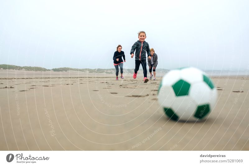 Soccer ball with people running on background Lifestyle Joy Happy Playing Beach Sports Success Child Human being Woman Adults Mother Grandmother