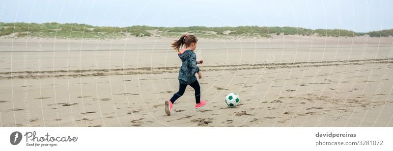 Little girl playing soccer on the beach Lifestyle Joy Playing Beach Sports Child Internet Human being Woman Adults Infancy Nature Plant Sand Autumn Fog Sneakers