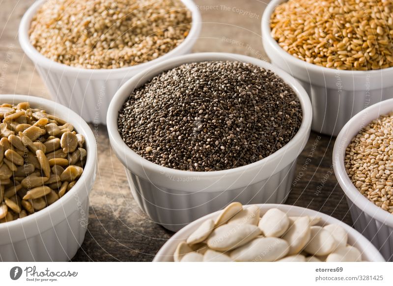 Assortment of different seeds in bowl on wooden table Food Healthy Eating Food photograph Seed Seeds Ingredients Grain Exceptional Pumpkin linen chia Sunflower