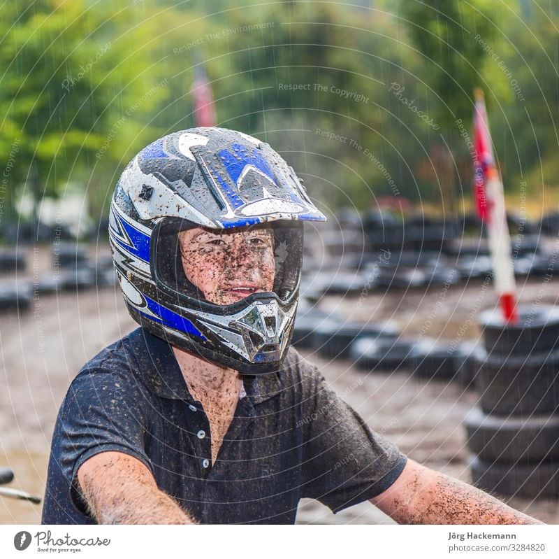 Boy likes to ride his quad bike in the course Joy Sports Engines Boy (child) Youth (Young adults) Nature Weather Rain Driving Wet Speed kart Buggy (Motorbike)