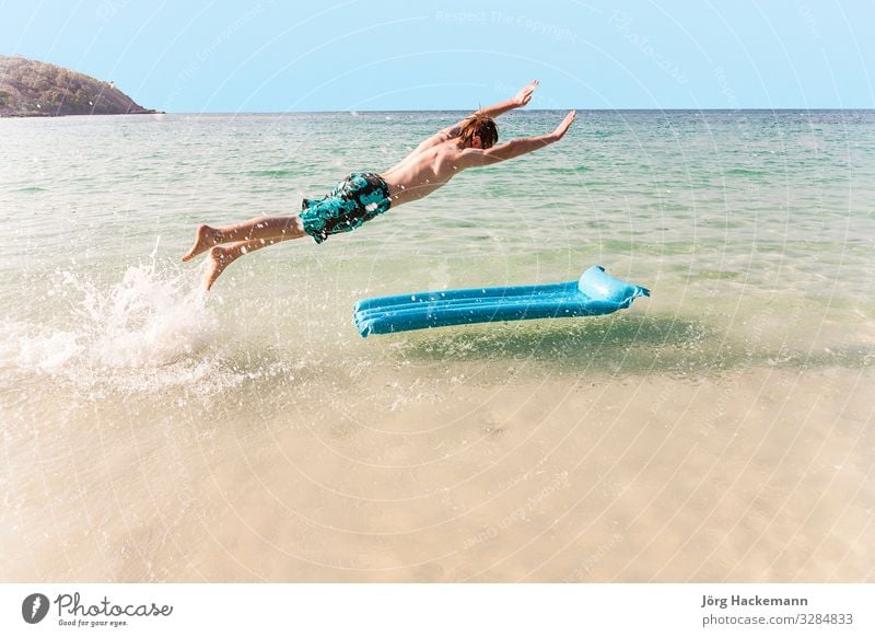 boy with red hair is enjoying jumping on the air mattress Joy Vacation & Travel Beach Ocean Island Waves Boy (child) Youth (Young adults) Sky Jump Cute Speed