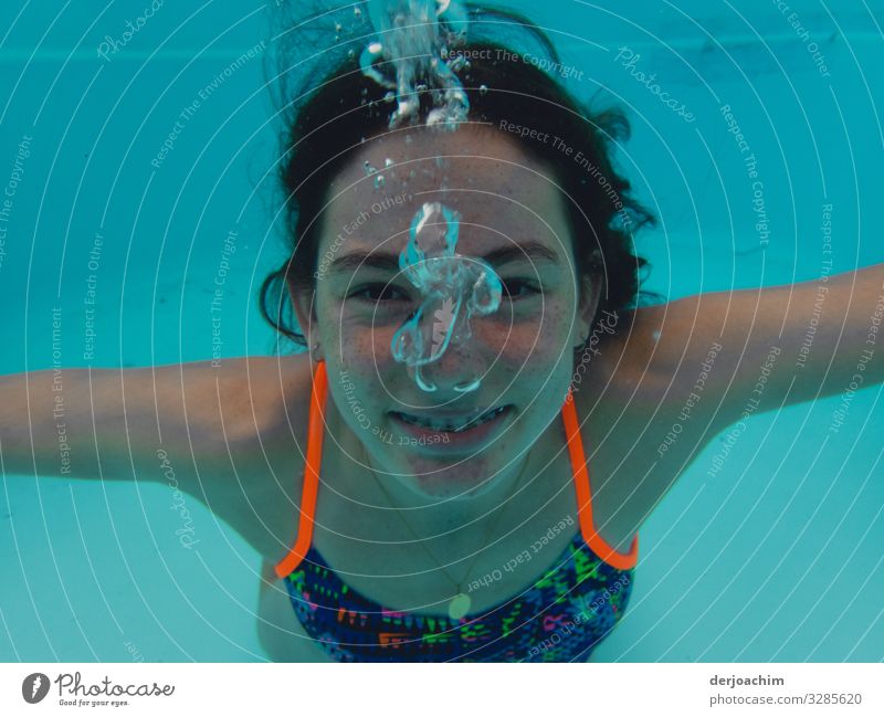 A girl under water looks at the photographer. She laughs and it goes blub blub.... Joy Athletic Life Swimming pool Aquatics Swimming & Bathing Girl