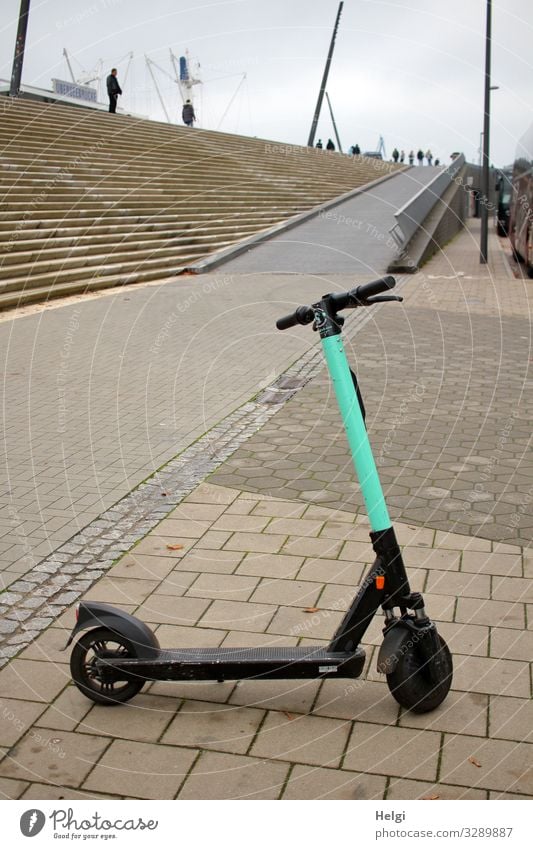 Electric scooter is parked on a sidewalk Tourism Trip Hamburg Port City Stairs Means of transport Street Vehicle e-roller Stone Metal Stand Wait Authentic