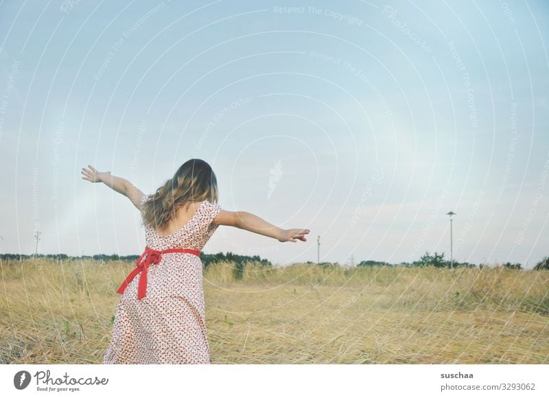 girl in a straw field playing "fly" Child Dress Exterior shot Nature Field Grain field Cornfield Landscape Summer Warmth Outstretched sleeves Bow Flying Playing