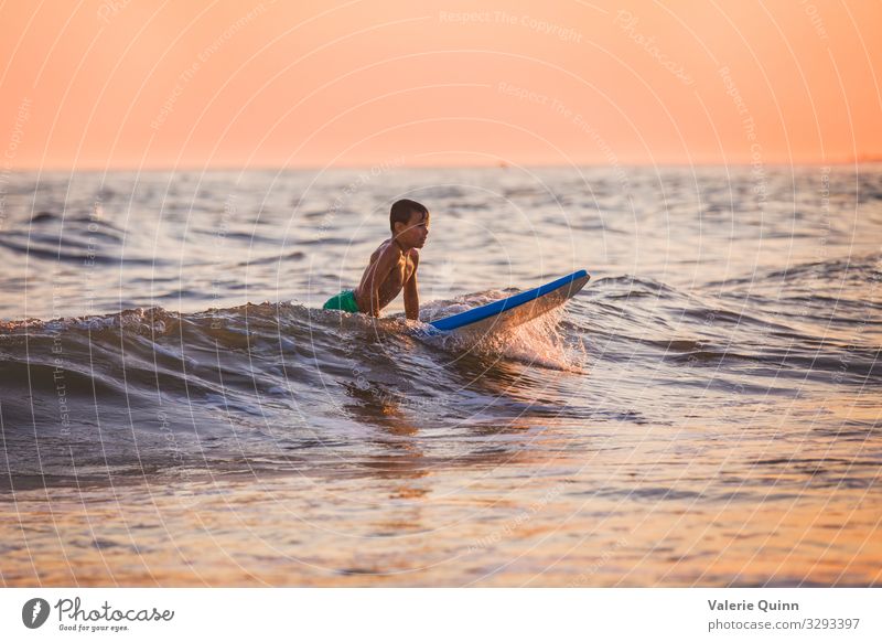 Surfing at Sunset Boy (child) 1 Human being 8 - 13 years Child Infancy Water Sky Horizon Summer Waves Beach Swimming trunks Joy Vacation & Travel surfing