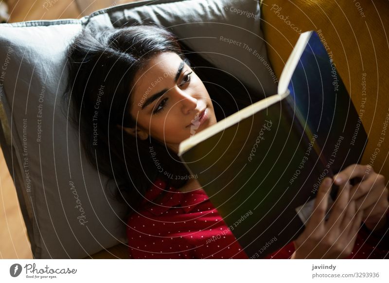 Persian woman at home reading on a couch Coffee Lifestyle Hair and hairstyles Relaxation Leisure and hobbies Reading Winter Flat (apartment)