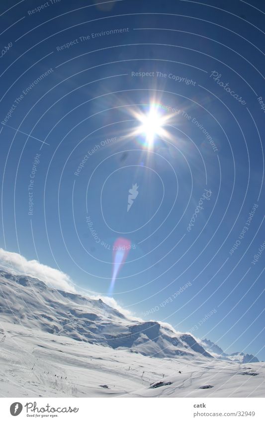 Mountain against the light Sun Snow Winter sports Skiing Ski run Landscape Cloudless sky Beautiful weather Alps Peak Snowcapped peak Switzerland Cold Blue White