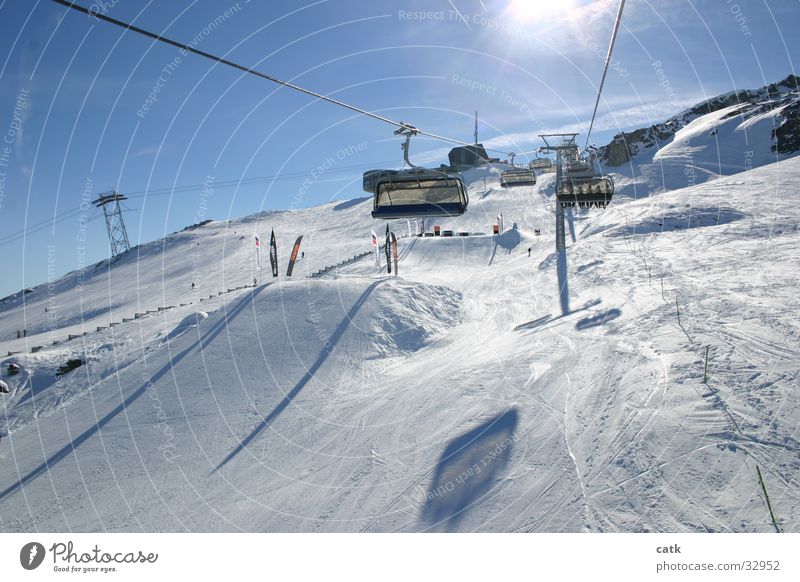 In the ski lift Vacation & Travel Sun Mountain Winter sports Skiing Ski lift Ski resort Skilift chair Ski run Sky Cloudless sky Beautiful weather Peak