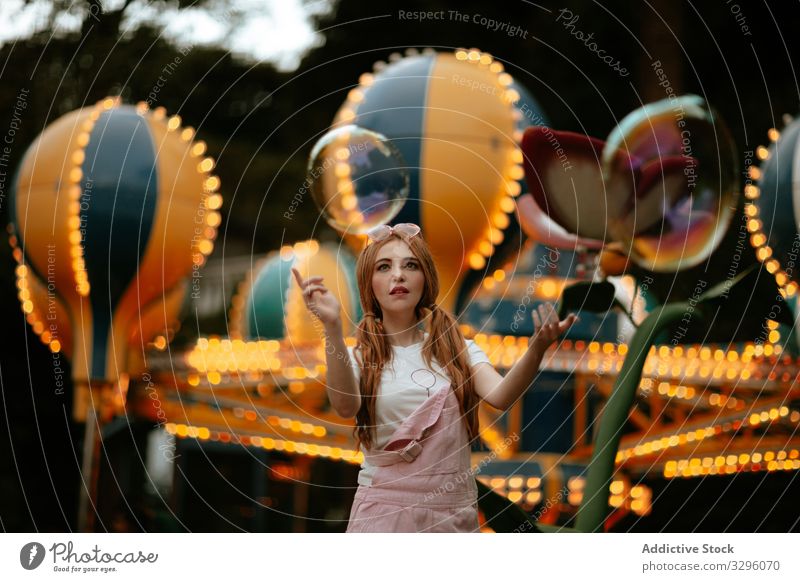 Teenage female playing with soap bubbles in amusement park woman girl teenager fun carefree playful enjoy style fashion trendy fashionable pure childlike young