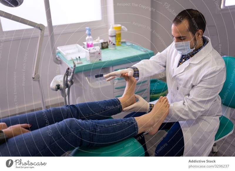 Podiatrist examining and treating patient doctor foot podiatry massage podiatrist clinic treatment procedure hospital healthcare medicine professional man