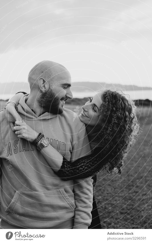 Hipster couple in love standing in field romantic embrace nature happy young together grass sit hug cuddle romance relationship tenderness happiness girlfriend