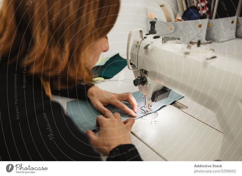 Seamstress using sewing machine in workshop seamstress woman fabric craft occupation material clothing female adult tailor part element detail professional