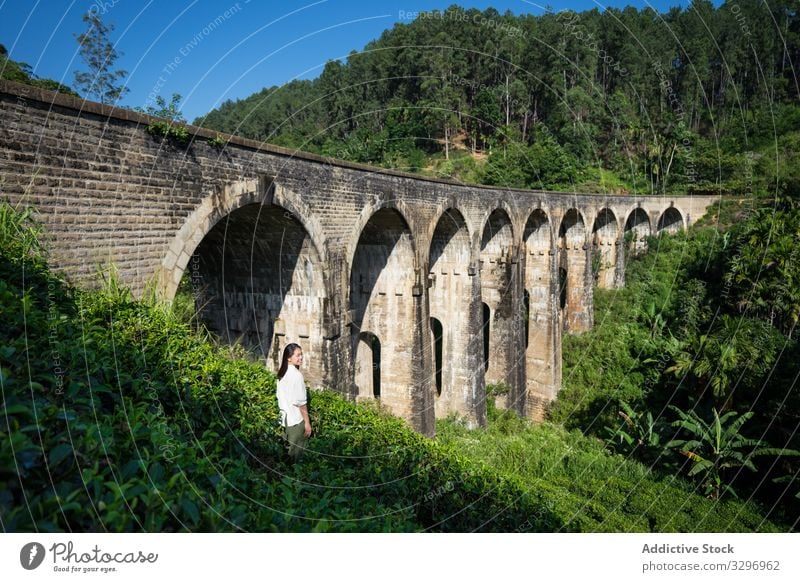 Young woman enjoying landscape of ancient bridge green forest old asian nine arches bridge shabby ella sri lanka touristic travel transportation architecture