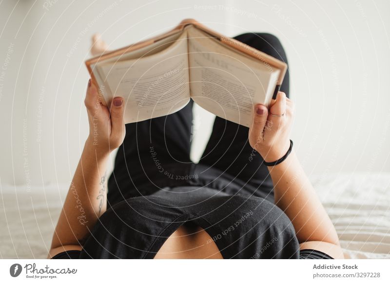 Unrecognizable woman reading book on bed at home enjoy pastime lay novel literature comfortable education female relaxation peaceful knowledge study rest cozy