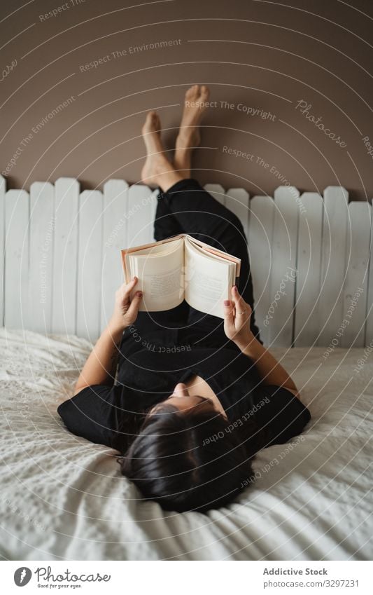 Unrecognizable woman reading book on bed at home enjoy pastime lay novel literature comfortable education female relaxation peaceful knowledge study rest cozy