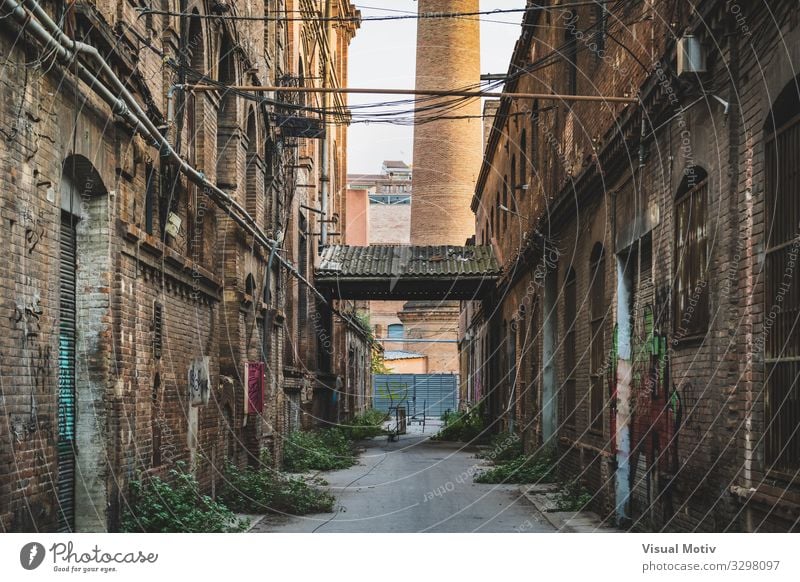 Frontal perspective of the alley of an old textile factory Town Industrial plant Factory Manmade structures Building Architecture Wall (barrier) Wall (building)