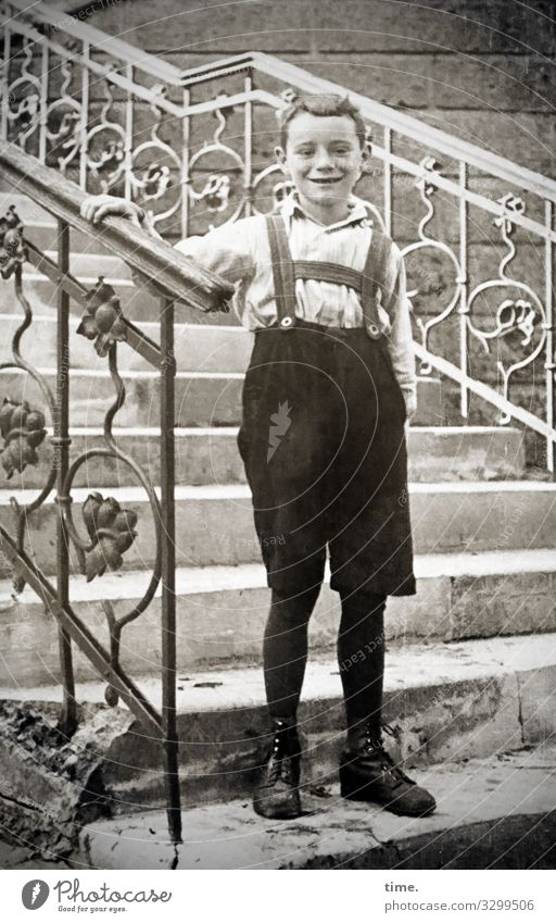 shy Masculine Boy (child) 1 Human being Wall (barrier) Wall (building) Stairs Steps Banister Shirt Pants Suspenders Boots Short-haired Observe To hold on smile