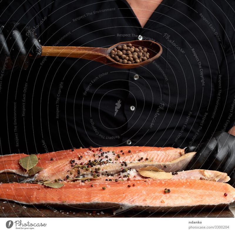 carcass of fresh salmon fish Meat Fish Seafood Herbs and spices Nutrition Dinner Spoon Table Kitchen Man Adults Gloves Wood Fresh Red Black chef cook cooking