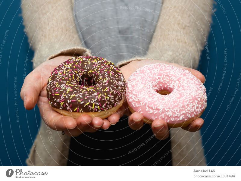 Woman holding a delicious colorful donut Dessert Breakfast Diet Skin Adults Hand Fingers Delicious Yellow Pink Black White Donut sweet Snack isolated food Hold