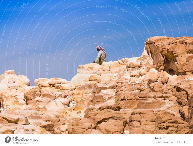 Bedouin sitting on the peak of a high rock in Egypt Relaxation Calm Vacation & Travel Summer Mountain Human being Man Adults Nature Landscape Sky Clouds Rock