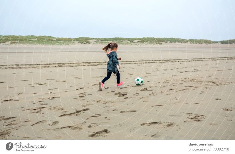 Girl playing soccer on the beach Lifestyle Joy Leisure and hobbies Playing Beach Sports Child Human being Woman Adults Infancy Nature Plant Sand Sky Autumn Fog
