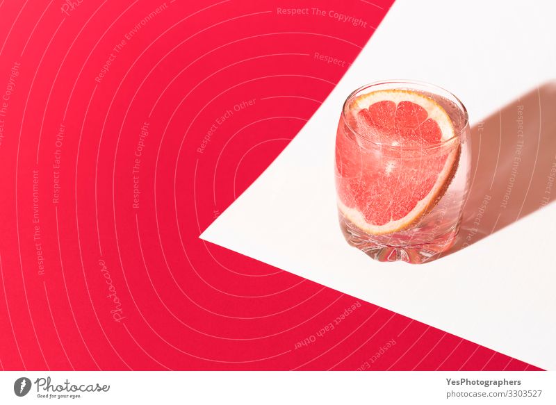 Cold grapefruit drink. Pink beverage. Grapefruit water. Cocktail Cold drink Drinking water Lemonade Glass Wellness Fresh Red citrus colorful Copy Space