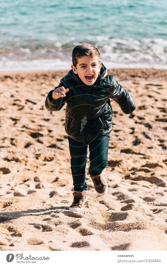 Little kid running on the beach in a winter day Lifestyle Joy Happy Beautiful Leisure and hobbies Playing Vacation & Travel Freedom Beach Ocean Winter Child