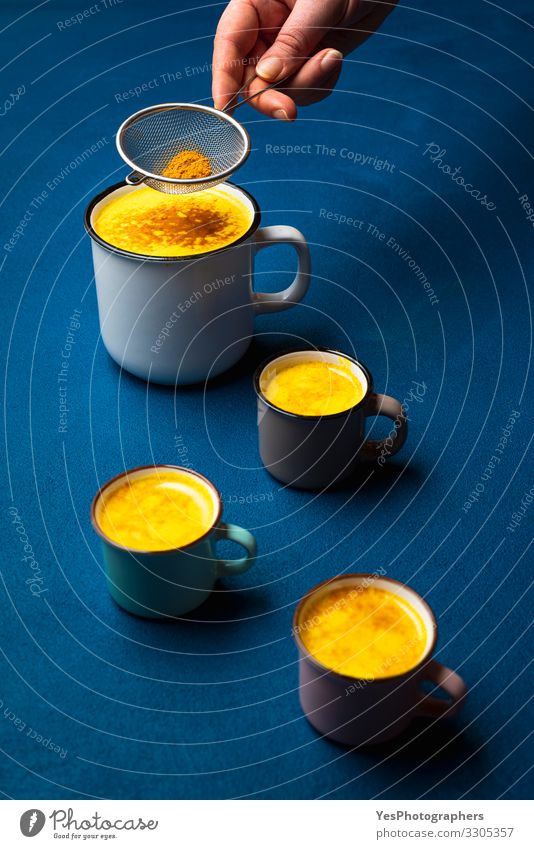 Turmeric latte in cup and spice powder. Warm detox turmeric milk Herbs and spices Beverage Hot drink Milk Cup Health care Healthy Natural Blue Yellow Colour