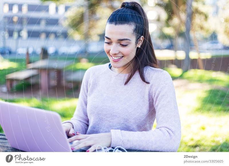 Young beautiful woman sitting outdoors while working with computer Lifestyle Happy Beautiful Academic studies Work and employment Business Computer Notebook