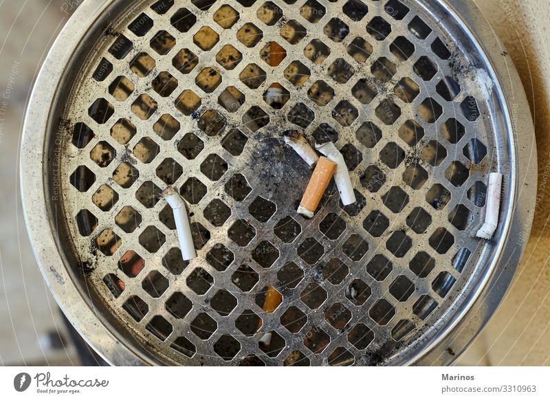 Closeup view of big ashtray with dropped cigarettes. Illness Stand Dirty Ashtray Cigarette butt health smoke Unhealthy addiction Cancer garbage tobacco