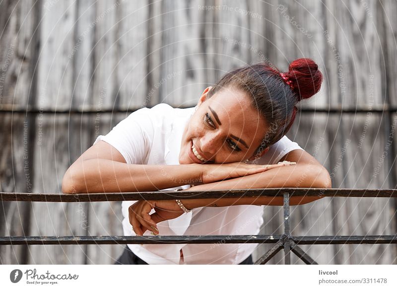 Beautiful young cuban woman leaning on a railing Lifestyle Happy Island Human being Young woman Youth (Young adults) Woman Adults Facade Balcony Street To enjoy
